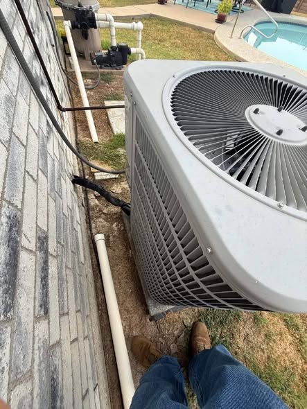 Outdoor AC condenser beside a home
